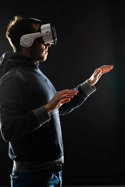 Portrait of computer hacker in virtual reality headset. Man in VR helmet. Data thief, internet fraud, darknet and cyber security concept. - Foto, imagen
