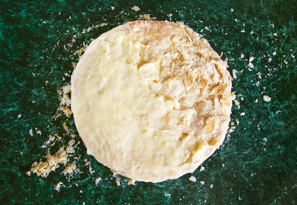 Gâteau napoléon en couches rondes avec crème anglaise et miettes saupoudrées sur une table en marbre vert, vue sur le dessus. Le processus de cuisson, recettes de desserts
. - Photo, image