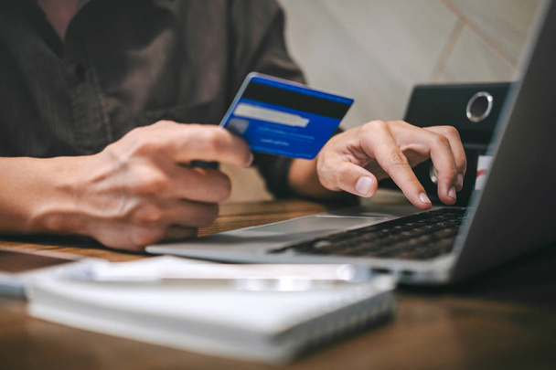Бизнесмен держит кредитную карту и печатает на ноутбуке для онлайн
  - Фото, изображение
