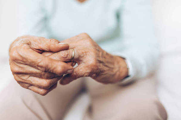 Heartbroken elderly woman holding a wedding ring - 写真・画像