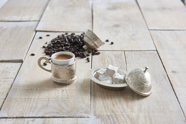fából készült asztal és csésze kávét étellel a háttérben - Fotó, kép
