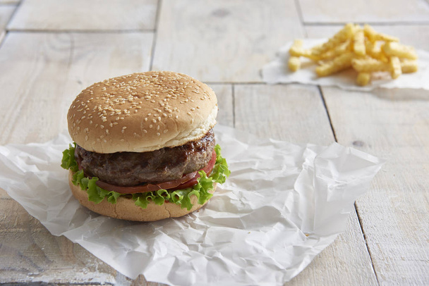 Hamburger mit frischem Gemüse auf Holzboden - Foto, Bild