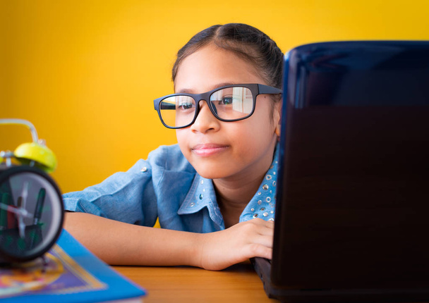Menina bonito usando óculos usando laptop na mesa grito isolado
 - Foto, Imagem