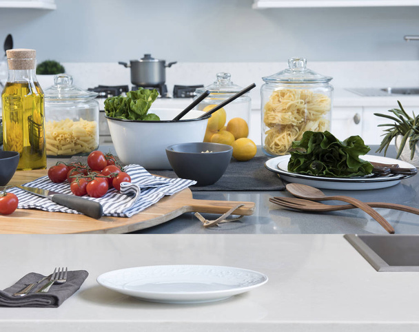 ruoanlaitto keittiössä ja salaatti taustalla, lähikuva
 - Valokuva, kuva