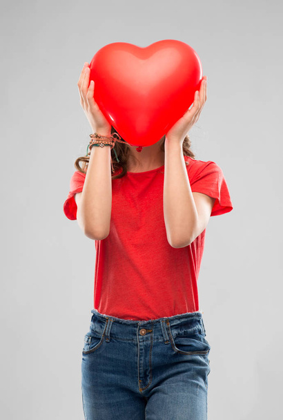 teenage girl with red heart shaped balloon - 写真・画像