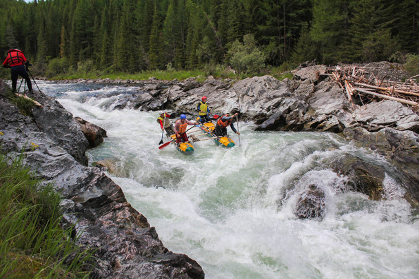 Altai Republic / Russia - June 30 2016: Extreme rafting on the Bashkaus River, extreme sportsmen go through the difficult turbine rapid on a catamaran.  Clean air of Altai and the beauty of Siberia - Foto, Imagem
