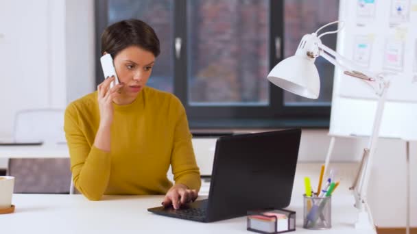 businesswoman calling on smartphone at office - Кадри, відео