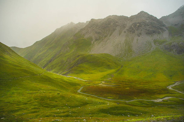 Мягкий свет солнца достигает зеленого высокого плато в немецких Альпах Высокий Мур в немецких Альпах с зелеными холмами и облачной вершине горы
 - Фото, изображение
