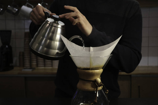 Mies keittää kahvia Kemeksin ja vedenkeittimen käsissä. Barista on töissä kahvilassa. Kahvilassa. Barista-poika. Yksi vaihe fantastisen kahvin keitossa. kemex
 - Valokuva, kuva
