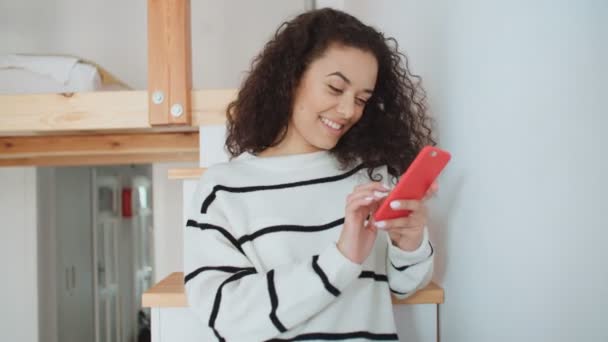 Charming young woman using phone at modern stylish apartment. - Video, Çekim