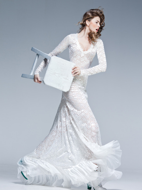 mooie vrouw in lange witte jurk poseren mode in de studio - Foto, afbeelding