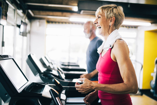 Picture of mature people running on treadmill in gym - Valokuva, kuva