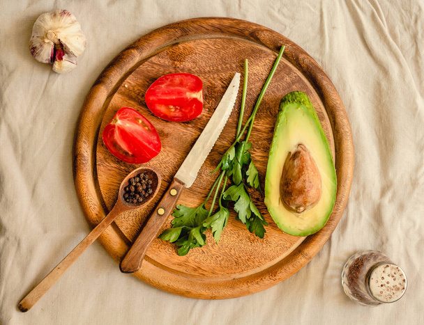 Ingredients for guacamole on a wooden board. Parsley, avocado, t - Photo, Image