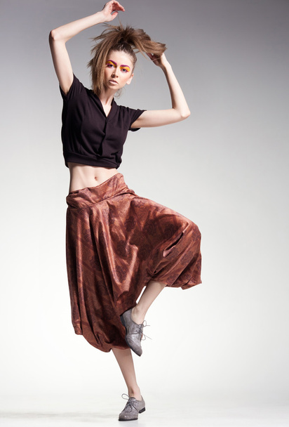 sexy woman model jumping in large pants - studio fashion shot - Foto, Imagem