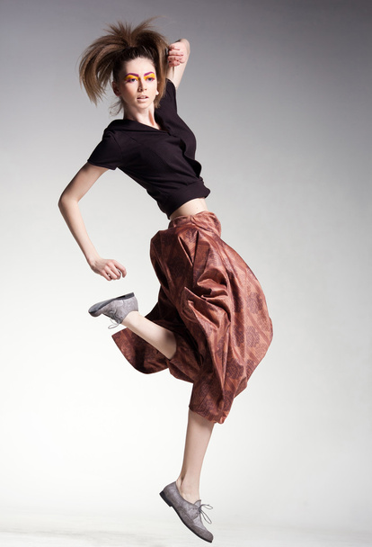 сексуальна жінка модель стрибає у великі штани студійний модний знімок
 - Фото, зображення