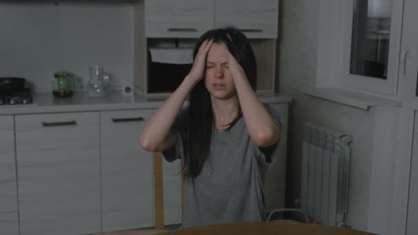Woman with headache in the kitchen at night. Insomnia and depression. - Felvétel, videó