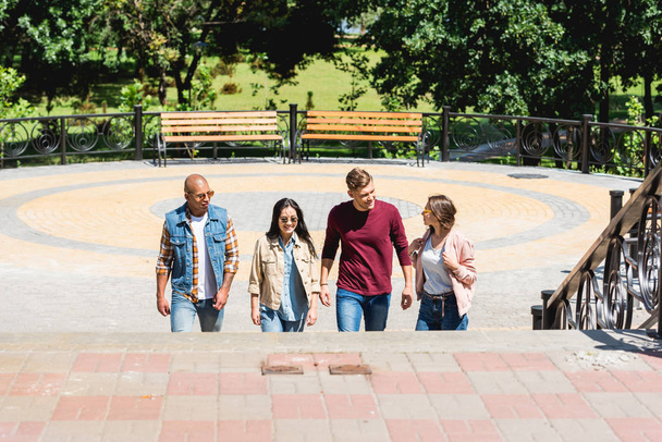 мультикультурная группа друзей, улыбающихся в парке
 - Фото, изображение