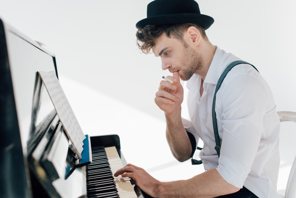 thoughtful musician composing music while sitting at piano  - Valokuva, kuva