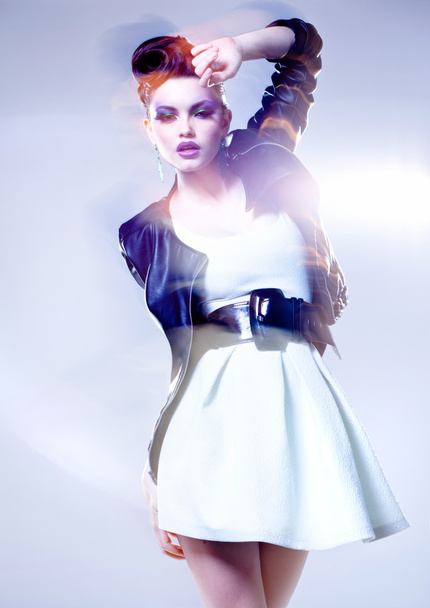 όμορφη γυναίκα που θέτουν σε ένα δερμάτινο σακάκι - εσκεμμένη κίνηση φως και χρώματα - Φωτογραφία, εικόνα
