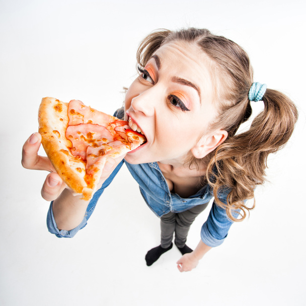 mignonne fille drôle avec deux queues de poney manger de la pizza plan grand angle
 - Photo, image