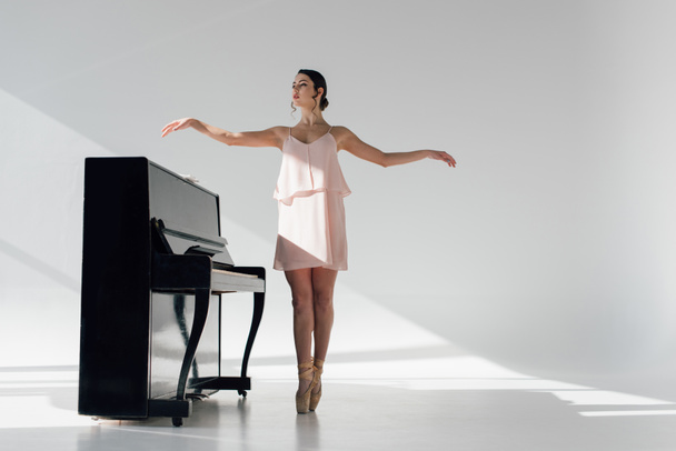 joven bailarina atractiva bailando cerca de piano negro
  - Foto, imagen