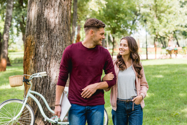 cheerful man looking at beautiful girl with hand in pocket  - Photo, Image