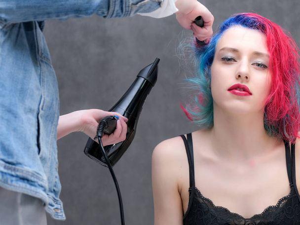 Portrait of a hairdresser makeup artist beautician. Model with red multi-colored hair. Head washing, hair dyeing, makeup application, hair styling. - 写真・画像