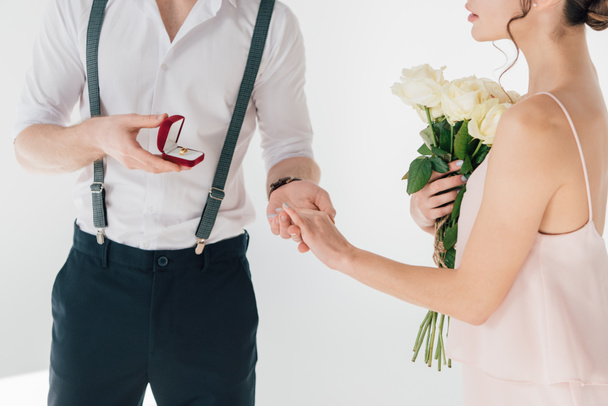 cropped view of man making marriage proposal to girl with bouquet of roses - Φωτογραφία, εικόνα