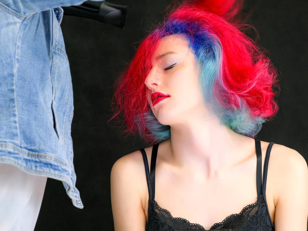 Portrait of a hairdresser makeup artist beautician. Model with red multi-colored hair. Head washing, hair dyeing, makeup application, hair styling. - Photo, image