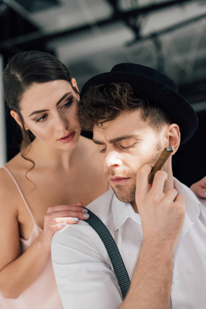 beautiful girl touching shoulder of confident man holding sigar - Foto, Bild