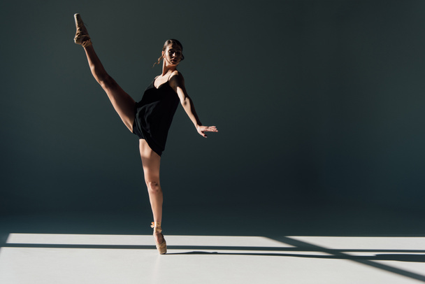 attractive ballerina dancing in black dress and pointe shoes  - Fotografie, Obrázek