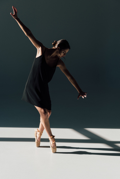 beautiful young ballerina dancing in black dress and pointe shoes  - Φωτογραφία, εικόνα
