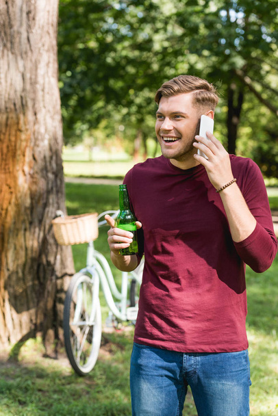 cheerful man talking on smartphone while talking on smartphone  - Fotó, kép