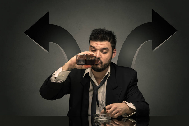 Drunk man sitting at table with arrows around - 写真・画像