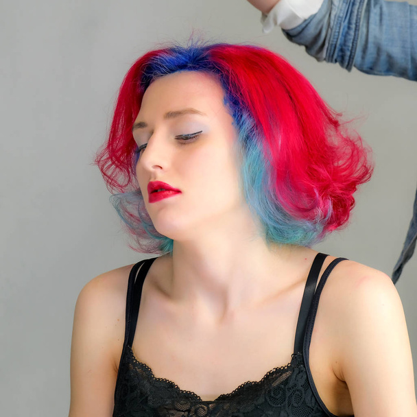 Portrait of a hairdresser makeup artist beautician. Model with red multi-colored hair. Head washing, hair dyeing, makeup application, hair styling. - Photo, Image