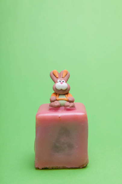 Easter rabbit sitting on a austrian easter cake called Punschkrapfen. - 写真・画像