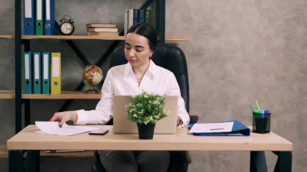 Young woman works with documents in office - Video, Çekim