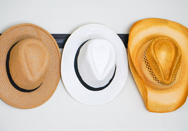 Una variedad de sombreros colgados en un gancho
 - Foto, imagen