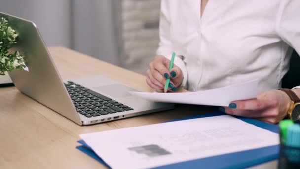 Крупним планом жіночі руки розбирають документи на робочому столі
 - Кадри, відео