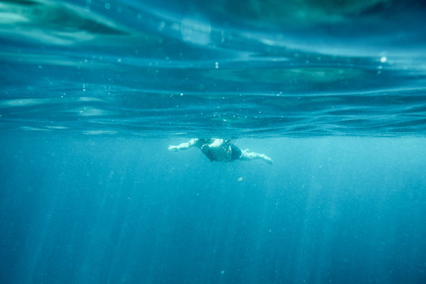 Man in de blauwe oceaan zwemmen - Foto, afbeelding