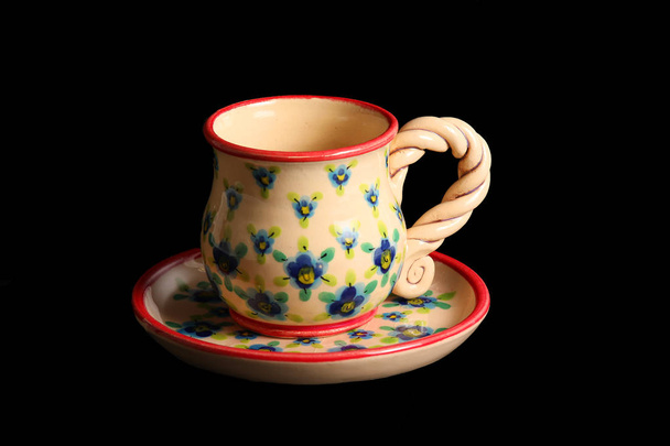 taza de café y platillo en flores y con un borde rojo sobre un fondo azul
 - Foto, Imagen