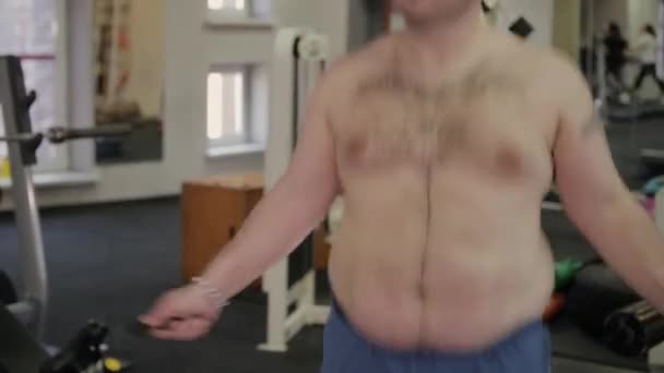 Fat man jumping rope in the gym. - Felvétel, videó