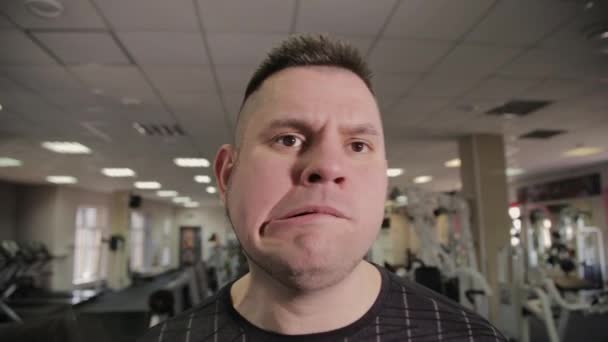 Fat Man trainiert mit Kurzhanteln im Fitnessstudio. - Filmmaterial, Video