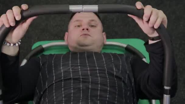 Hombre gordo entrena prensa en el suelo en el gimnasio
. - Metraje, vídeo