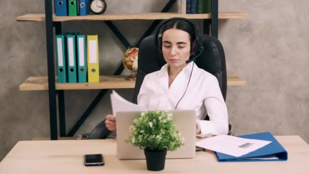 Female call center worker answers customer call - Filmati, video