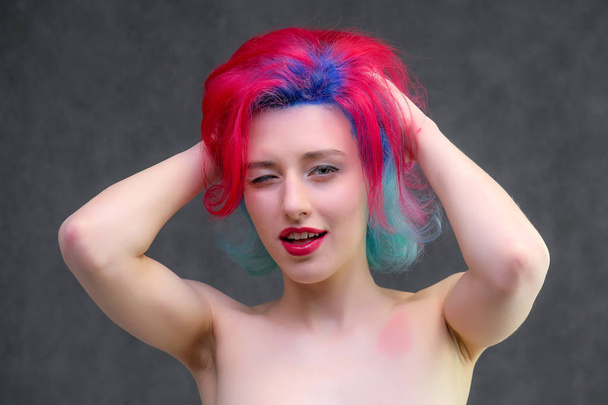 High fashion model woman with multi-colored hair posing in the studio, portrait of a beautiful sexy girl with a fashionable makeup. - Foto, Imagen