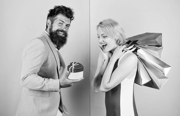 Everything she wants. Couple with luxury bags in shopping mall. Couple enjoy shopping. Man bearded hipster hold gift box and girl enjoy shopping. Ask man to purchase lots presents for girlfriend - Photo, Image