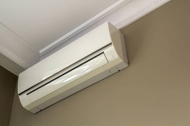 Cool airconditioner geïnstalleerd in kamer interieur op wit plafond en lichte muren kopie ruimte achtergrond. Airco, comfortabel huis concept. - Foto, afbeelding