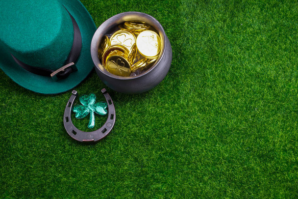 Happy St Patricks Day leprechaun hat with gold coins and lucky charms grass. Top view - 写真・画像