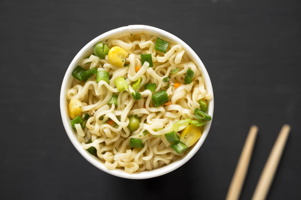 Tasty instant noodles with beef flavoring in a paper cup over bl - Photo, Image
